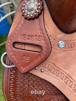 15 silver studded Western barrel saddle withtooled leather, roughout fenders