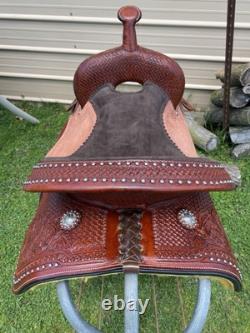 15 silver studded Western barrel saddle withtooled leather, roughout fenders