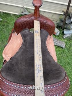 15 silver studded Western barrel saddle withtooled leather, roughout fenders