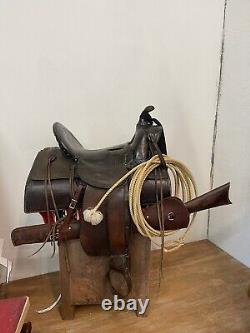 Antique cowboy saddle with rifle scabbard
