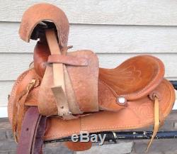 Lightly used 12 US made tooled light oil leather pony saddle withsafety stirrups
