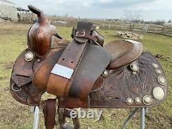 Used/vintage Simco 15 tooled Western saddle withsilver conchos