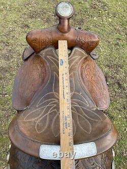 Used/vintage Simco 15 tooled Western saddle withsilver conchos