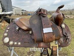 Used/vintage Simco 15 tooled Western saddle withsilver conchos